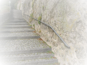 Begleitung. Eine lange Steintreppe mit schmalem Geländer